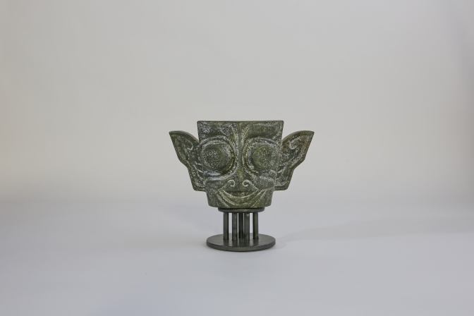 Maske aus Jade auf einem Metallsockel