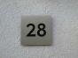 Hausnummer 28 aus Edelstahl mit schwarzem Plexiglas hinterlegt