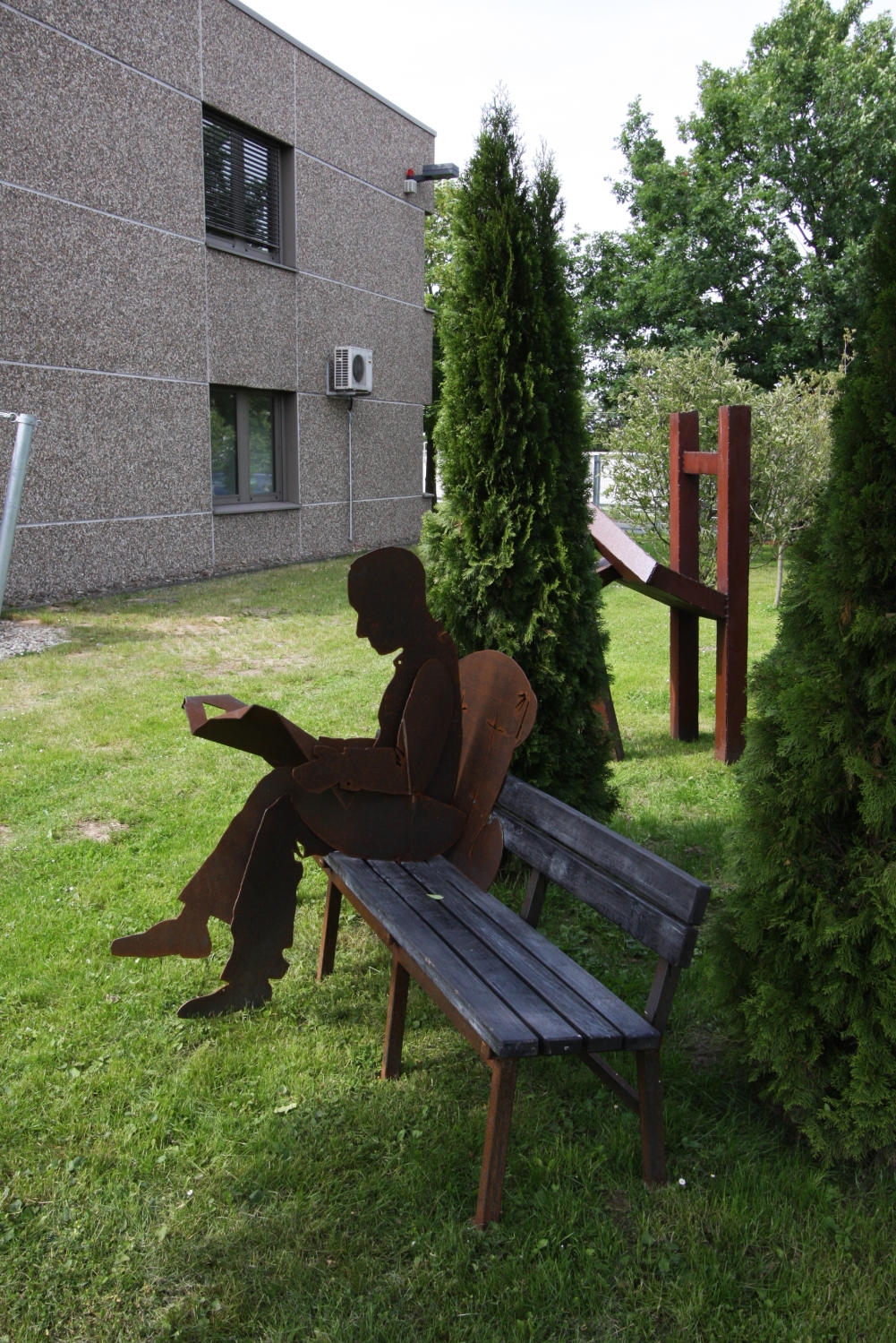 skulpturale Garten Bank mit einem Zeitungsleser aus rostigem Stahl für die SOCON SONAR CONTROL Kavernenvermessung GmbH