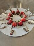 Gefüllte Erdbeere mit hausgemachtem Nussschinken auf einem Parmesanbett