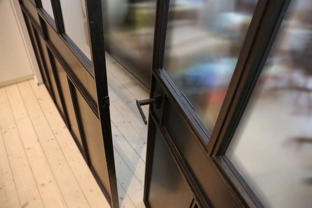 Glastrennwand im Industrie Look, unten mit Blech gef&uuml;llt.