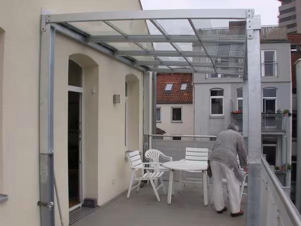 Terrassen&uuml;berdachung mit Glasf&uuml;llung f&uuml;r einen Balkon im 5. Stock