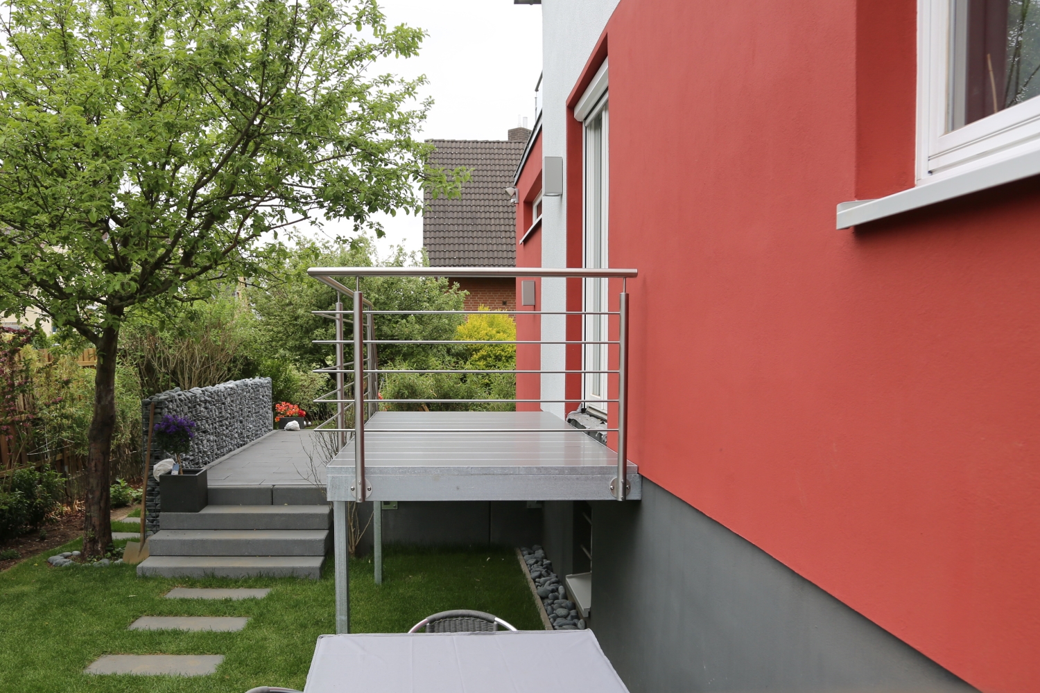 Treppe mit einem Edelstahl Geländer und einem Podest.