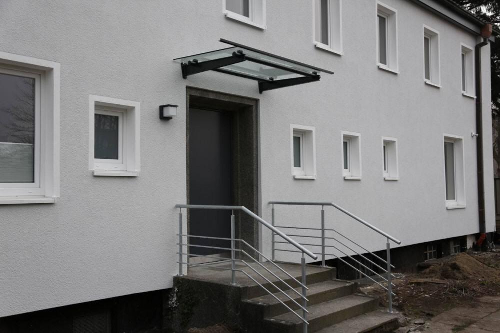 Vordach aus lackiertem Stahl und Glas