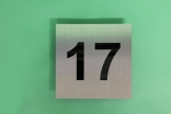 Hausnummer 17 aus Edelstahl mit schwarzem Acrylglas hinterlegt