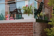 Balkongeländer aus Edelstahl, Sicherheitsglas und einer lackierten Balkonplatten Verkleidung
