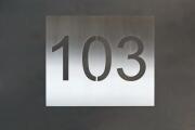 Hausnummer 103 mit negativ geschnittener Schrift