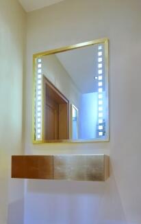 Wandhängendes, vergoldetes Sideboard mit hinterleuchtetem Spiegel