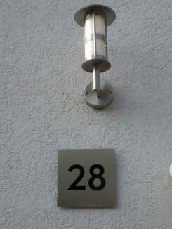 Hausnummer 28 aus Edelstahl mit schwarzem Plexiglas hinterlegt