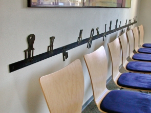 Wandschutz und Rammschutz mit gelaserten Stühlen für eine Wartezone in einer Arztpraxis