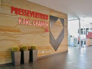 Wandgestaltung mit einem Logo aus Metall für den Pressevertrieb Karl Crämer KG