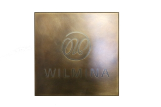 Logo aus Tombak mit Edelstahl hinterlegt