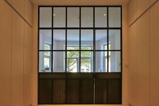 Glastrennwand im Industrie Look, unten mit Blech gefüllt.