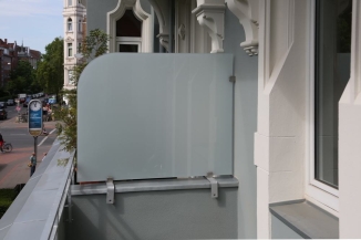 Windschutz und Balkontrennwand an einem denkmalgeschütztem Haus.