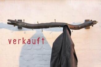 wandhängende Garderobe aus einem geflämmten Ast