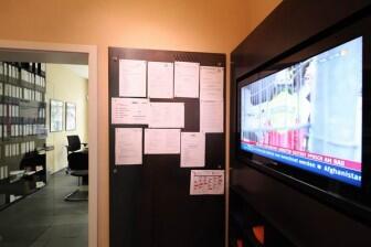 Monitorwand mit integriertem Prospekthalter und Regalfächern aus Stahl für das Helmut Kohl Haus in Hildesheim