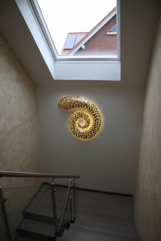 dreidimensionale Spiralstruktur aus Stahlblech geschweißt, vergoldet und mit LED hinterleuchtet