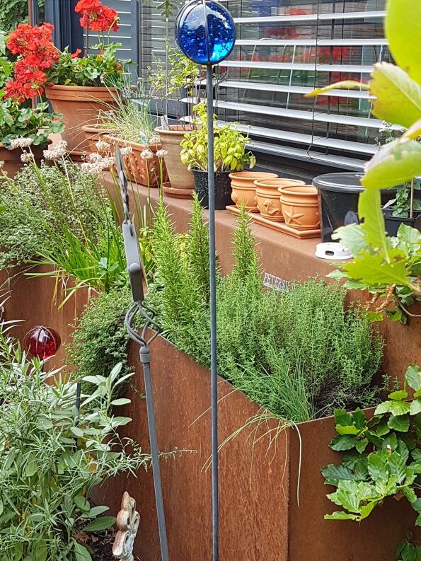 Treppe aus rostigem Eisen mit Hochbeeten für Kräuter