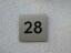 Hausnummer 28 aus Edelstahl mit schwarzem Plexiglas hinterlegt