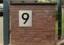 Hausnummer 9 aus Edelstahl mit schwarzem Acrylglas hinterlegt