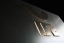 Verzunderter Stahl mit Messingabrieb und hinterleuchtetem Edelstahl-Logo