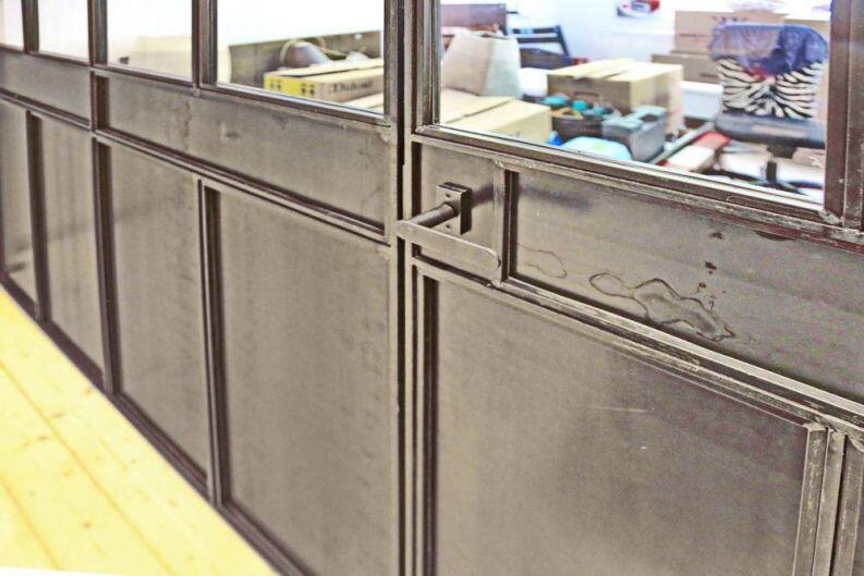 Glastrennwand im Industrie Look, unten mit Blech gefüllt.