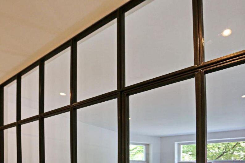 Glastrennwand im Industrie Look, unten mit Blech gefüllt.