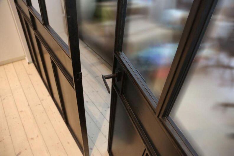 Glastrennwand im Industrie Look, unten mit Blech gefüllt.