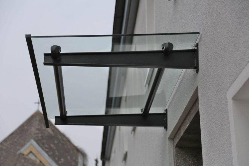 Vordach aus lackiertem Stahl und Glas